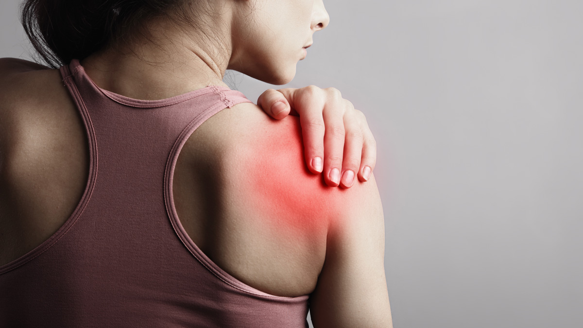 Woman in a tank top holding her sore shoulder, with redness indicating pain. Blue-Emu provides targeted relief for muscle aches.